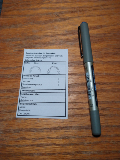 Photo of a miniature form lying on a desk next to a pen. The form is apparently from the German health ministry's department for Tooth fairies, worry eaters and other magical support services. The form allows you to specify which tooth you have lost, so the tooth fairy will still visit, even if you don't have the tooth.