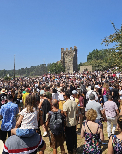 Multitudes de gente en torno a una de las antiguas torres de vigilancia de Catoira.