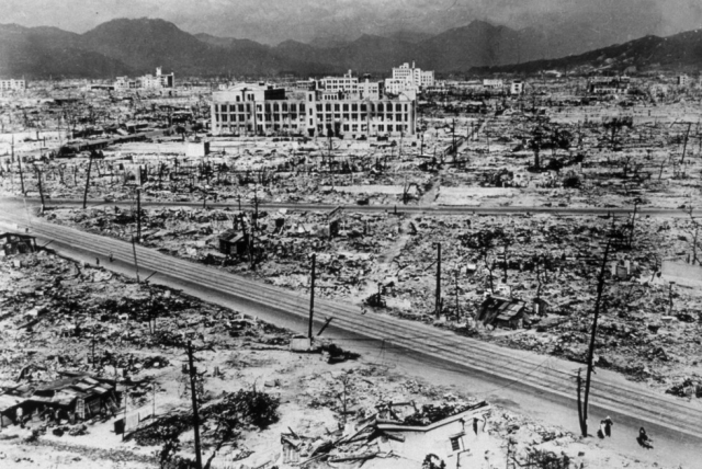 A bleak, vast panorama of utter devastation, with very few buildings left standing, in the aftermath of the atomic bomb being dropped on Hiroshima.