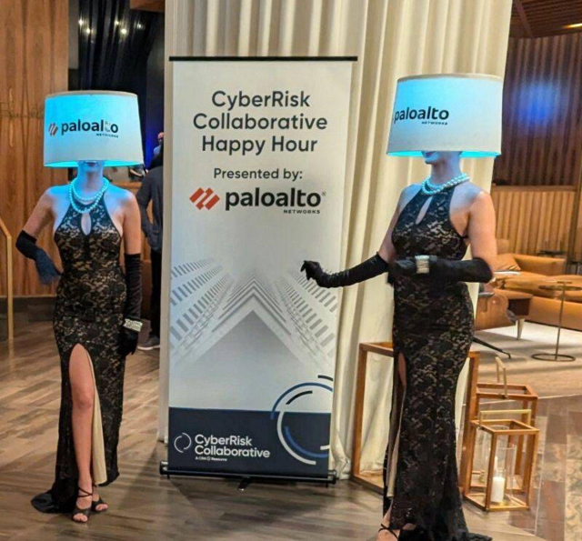 Women (models) in a fancy dress wearing a lampshade over their head the Palo Alto Networks' CyberRisk Collaborative Happy Hour