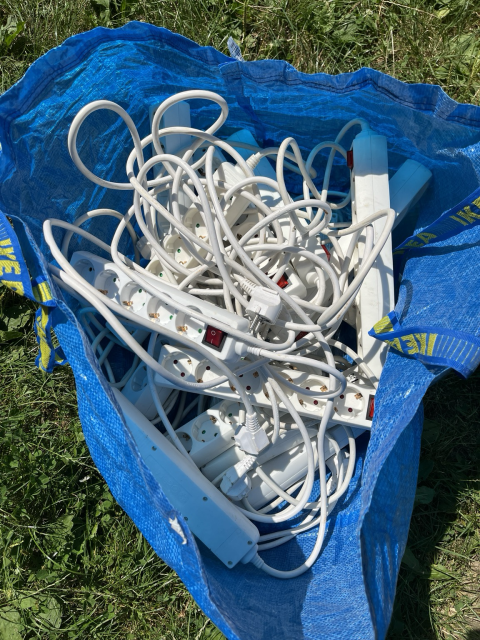 An Ikea bag with a lot of power cords/extensions.