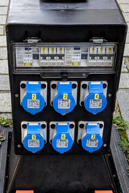 An outdoor power splitter box with six single phase 16A IEC 60309 sockets numbered 2 - 7.

Above them are two four-pole 40/0.03 RCDs signed 2-4 and 5-7 respectively, as well was 6 circuit breakers of type C16 numbered from 2 to 7.