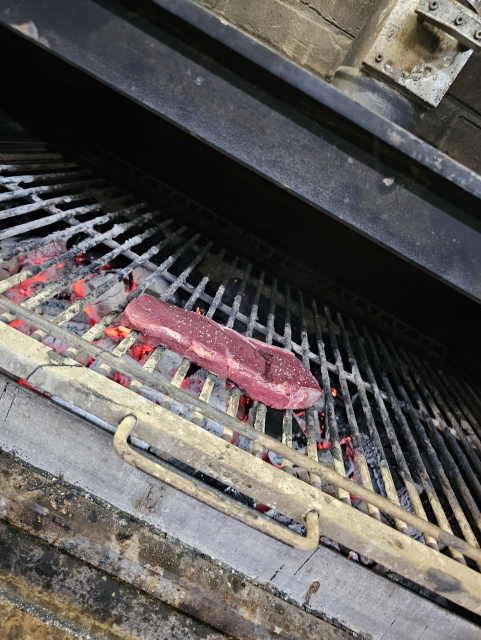 hovädzí stejk na rošte v Josper grile, pod roštom rozžhavené uhlie