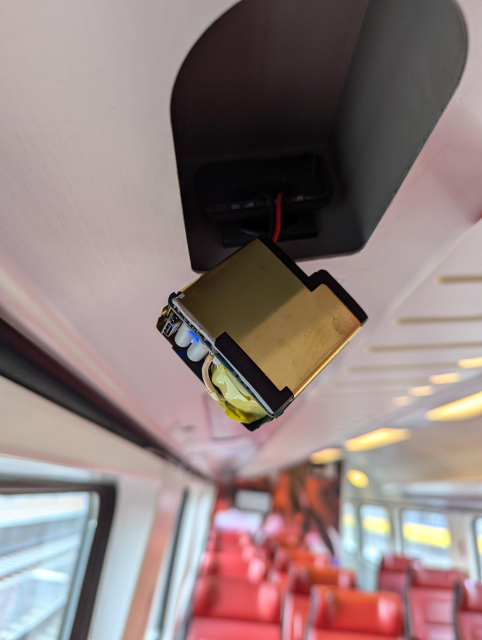 Internals of a USB Type-C power supply hanging out of a socket. There's a blue light shining near the USB connector.