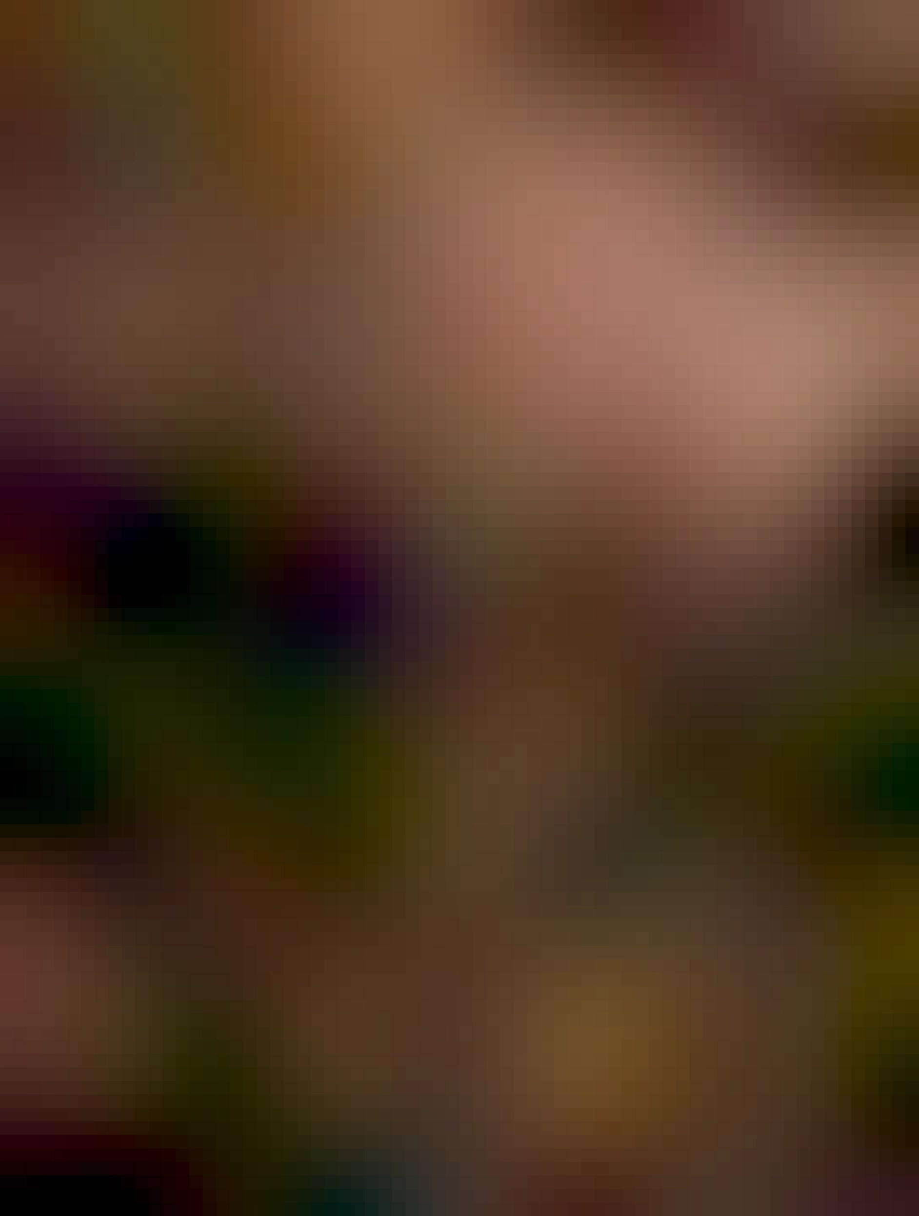 tmavá mačka sedí na betóne vedľa pneumatiky čo leží v záhradke pred činžovním vchodem, v okolí rastie niekoľko kríkov s trávou a burinou