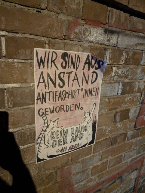 Ein selbstgemachtes bzw. selbstgezeichnetes Plakat, welches an einer Backsteinmauer aufgehängt wurde. Auf einem rötlich verwaschenen Hintergrund steht in schwarzen , großen Buchstaben: "Wir sind aus Anstand Antifaschist*innen geworden."
Darunter sind zwei Katzen zu erkennen, die ein Transparent festhalten. darauf steht: "Kein Raum der AFD. 161 Area." 161 steht für die Buchstaben AFA, was Antifaschistische Aktion bedeutet.