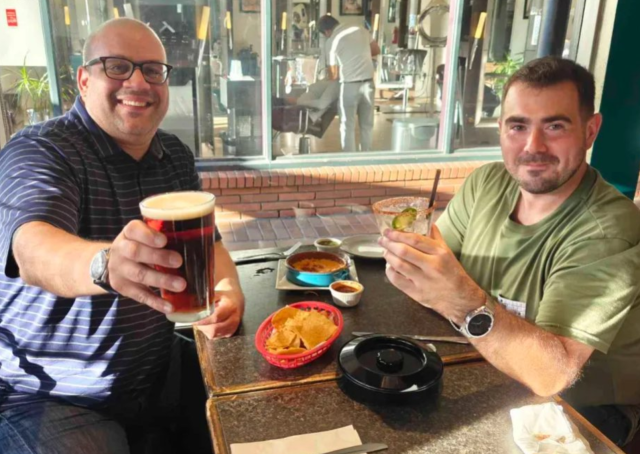 Two dapper gentlemen enjoying drinks.