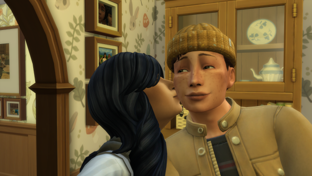 Screenshot from The Sims 4, showing two people - a woman black hair and a man wearing a hat - taking a selfie in a family home. The woman is kissing the man on the cheek.