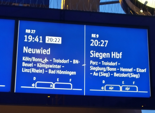 Electronic display showing one train delayed for 39 minutes arriving five minutes before another one following a similar route.