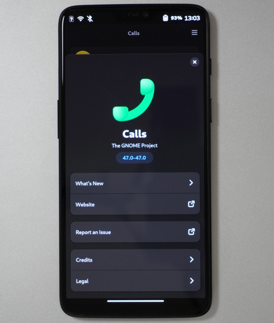 The "About" screen for version 47.0 of the GNOME Calls app, running on postmarketOS on a OnePlus 6. It's an `AdwAboutDialog` which is one of the fancy responsive UI features you can only use on GTK4 apps with libadwaita.