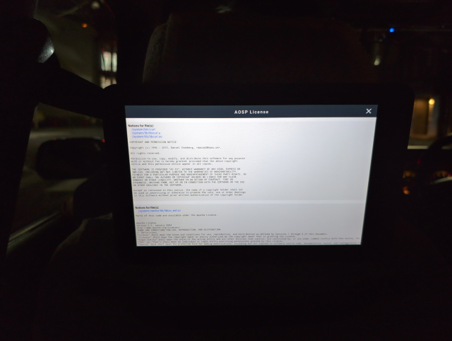 Photo of bright monitor in dark taxi cab. Monitor shows an "AOSP licences" screen, where the topmost entry is curl.