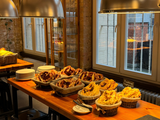 A food stand with delicious bretzels on it. There is a warm light above the stand.