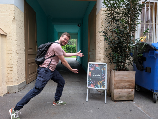 Thibault Martin posing next to the Matrix Conference signage at the entrance to the venue.