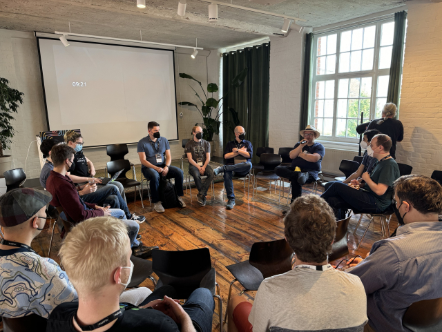 A group of people sitting in a circle talking together 