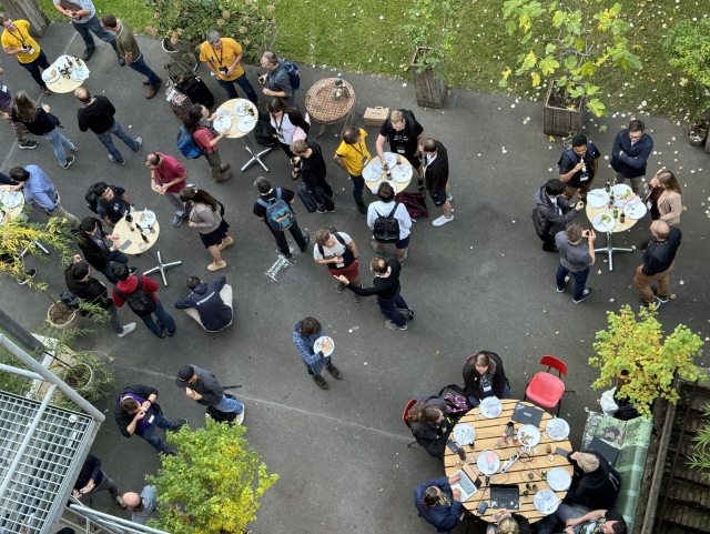 A picture of a crowd in a garden, socialising, drinking and eating