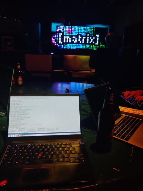 Picture of some laptop on the foreground and a animated matrix logo with leds in the background 