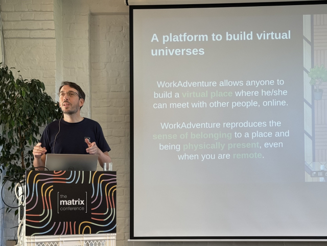 A photo of the speaker David Négrier, in front of his slides introducing the Workadventure platform