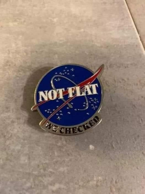 A blue and red circular enamel badge based on the NASA logo with "NOT FLAT" on the blue badge and then "WE CHECKED" in black on silver underneath