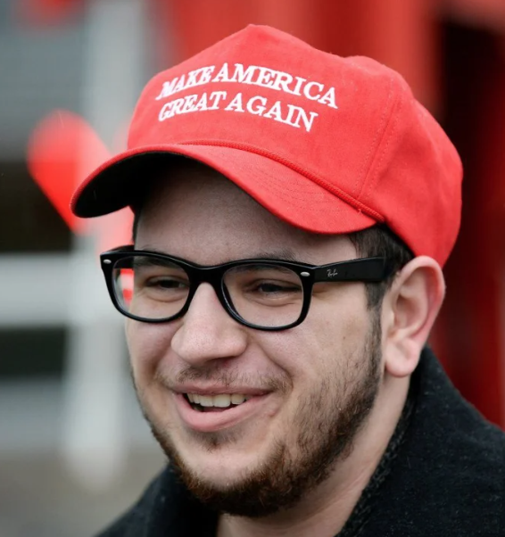 BC Conservative executive director Angelo Isidorou wearing a red "Make America Great Again" baseball hat.