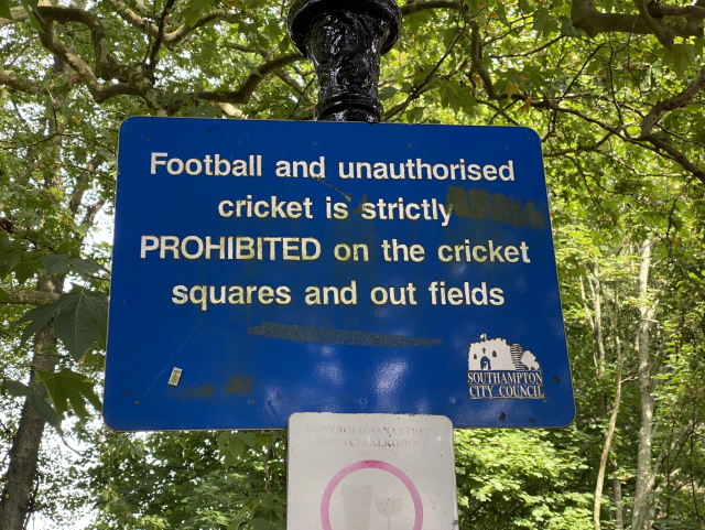 Ah blue sign reading: 

Football and unauthorised
cricket is strictly
PROHIBITED on the cricket
squares and out fields
