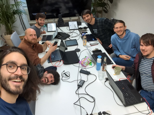 Selfie with a table of hackers at the JUCR office. Left to right: Tobias, Pablo, Robert, Jonas, Andrei, Luca, Newbyte.