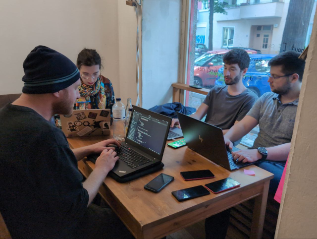 Four hackers working at a table at Offline. Left to right: Robert, Janis, Jonas, Adrian.