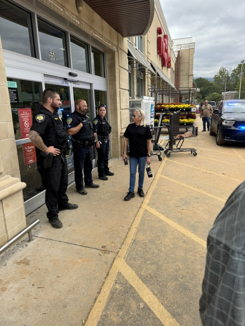 A photo of three uniformed cops blocking the entrance to Ingles in Black Mountain, NC. 