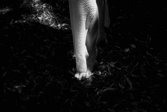 BW picture of a girl's feet in the forest