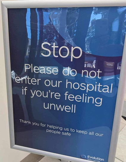 sign at the entrance to a hospital in the US saying Stop, please do not enter our hospital if you're feeling unwell