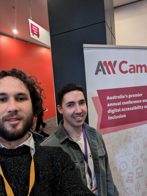 Sean with Riley Busch from the department of education in front of the A11y Camp banner