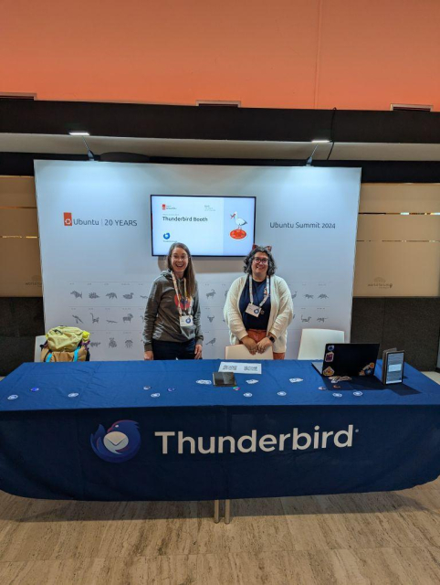 The Thunderbird booth at the Ubuntu Summit, with two very friendly, smiling members of the Thunderbird Team standing in back of it.