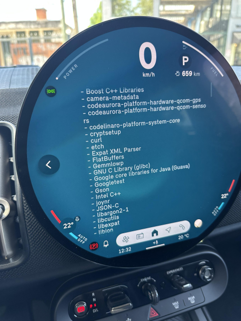 A circular dash screen in a car, listing open source components, including curl.