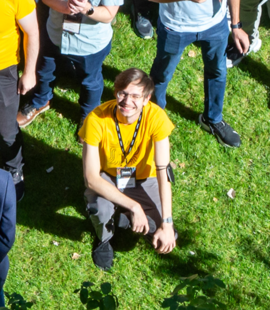 Me in a yellow shirt, sitting on grass and staring straight into the sun (camera)