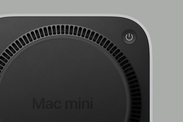 Product shot of the underside of the new Mac mini, showing a partially obscured ring of exhaust vents and a power button in one corner.