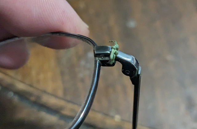 I will never ever shut up about this, ever. A faded green blade of grass, dried but no less vital, is tied around and through the screw hole in a pair of glasses, holding the lens securely and keeping a working writer able to see.