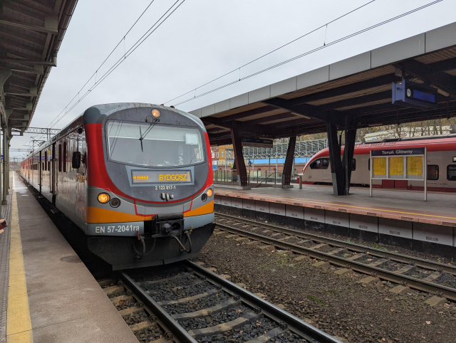 A class EN57 EMU arriving at a station.