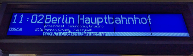 A departure board showing 5 minutes delay on a train to Berlin Hauptbahnhof