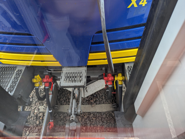 A view from the end of the train carriage to the link with the locomotive. 
The hook of the locomotive is empty and the train is apparently attached to the chain link of the locomotive.