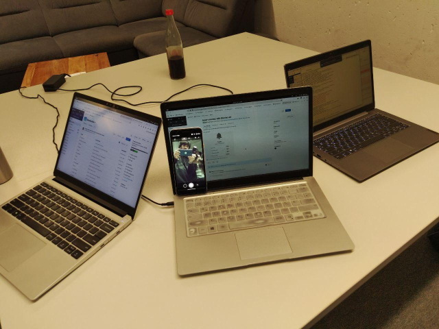 Our 3 laptops with the libadwaita MR (https://gitlab.gnome.org/GNOME/libadwaita/-/merge_requests/1330) on the front and the Pixel 3a with Snapshot previewing us taking the picture!