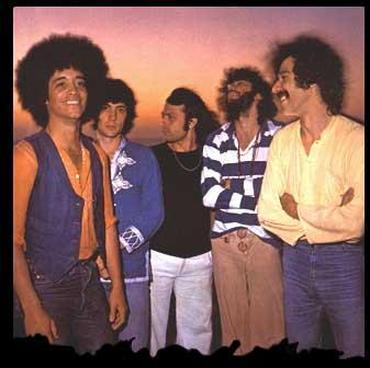 Imagen promocional, colorida y muy hippy (donde destaca Rubén Damtas con su pelo a lo afro a la izquierda de la imagen) del grupo Dolores, en una de sus formaciones. Discogs.