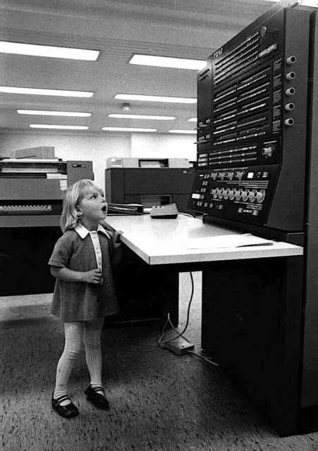 Small girl - no longer sad - amazed by an IBM 370 console.