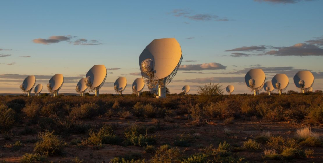 Many radio telescope dishes in a dry savannah, going off to the horizon.   This is the MeerKAT radio telescope array in South Africa.  Photograph from here:

https://www.cnn.com/2019/06/03/business/south-africa-meerkat-telescope/index.html