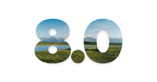 "8.0" cut out of an image of a grassy field and a snowy mountain range separated by a body of water