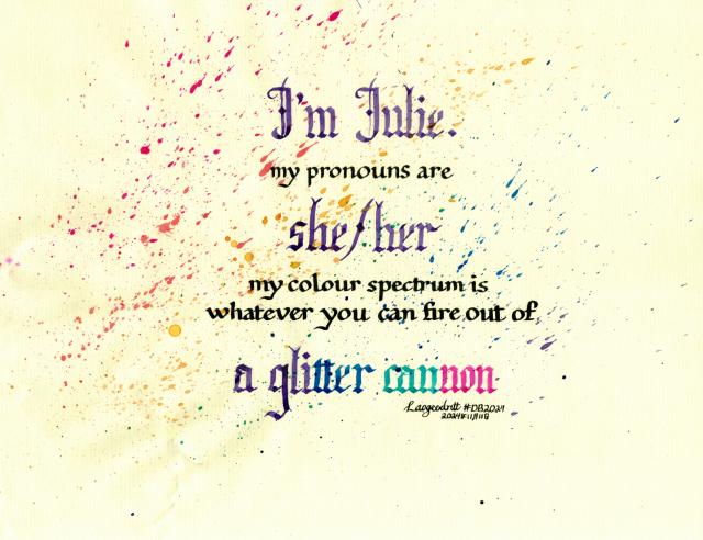 Calligraphy in a mixture of large textura quadrata script and small foundational hand. It reads: "I'm Julie. My pronouns are she/her. My colour spectrum is whatever you can fire out of a glitter cannon." On textured cream coloured-paper, with the queer pride rainbow colours splattered across the page, going diagonally upward (as if glitter shot out of a cannon).  Signed Laogeodritt, dated 11 November 2024.