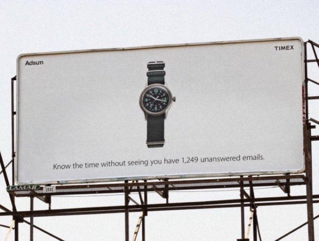 A billboard advertisement features a Timex watch on a white background. The text reads: "Know the time without seeing you have 1,249 unanswered emails."