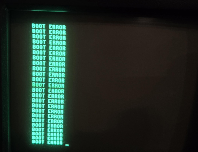 A monochrome green CRT display is filling the entire image. The text on this bad boy is *neon green* on black; we're talking some real Matrix shit here. The screen says "BOOT ERROR" repeating itself once per line and filling the entire screen. It's not obvious from the picture, but the screen is only 5 inches. It's SO small. Each line of text is maybe 3 millimeters tall?

Also not obvious from the picture is that this is on an Osborne 1 computer, and it is beautiful.