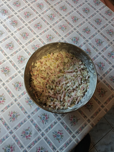 Na snímku je stůl s květinkovaným ubrusem. Na stole je nerezová mísa s domácím pařížským salátem.