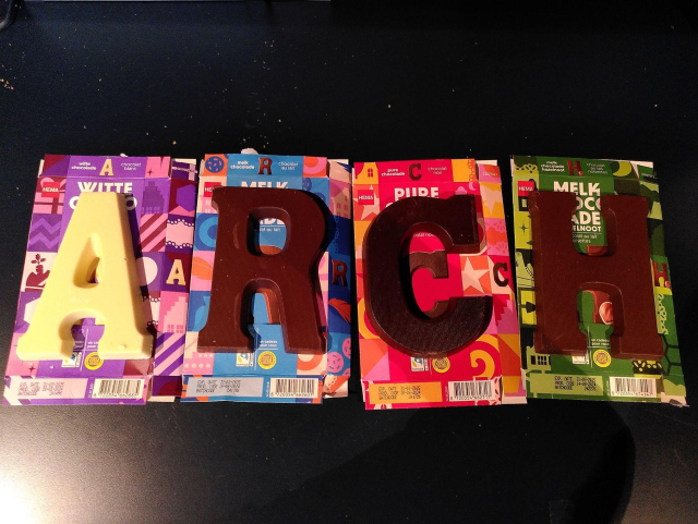 A picture with four large pieces of  Dutch christmas chocolate spelling ARCH