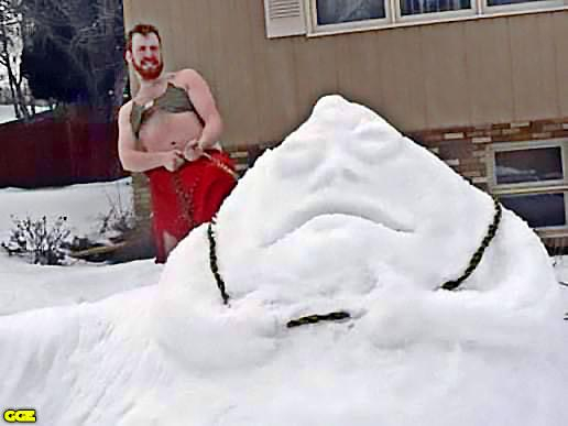 A man in a Slave Leia outfit uses a chain to strangle a snowman made to look like Jabba the Hut.