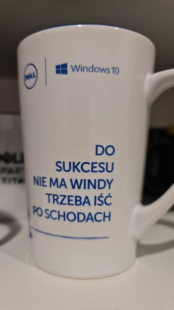 Photo of a white mug. The mug has a Dell logo, Windows 10 logo, and a marketing slogan in Polish, as explained in the main post. 